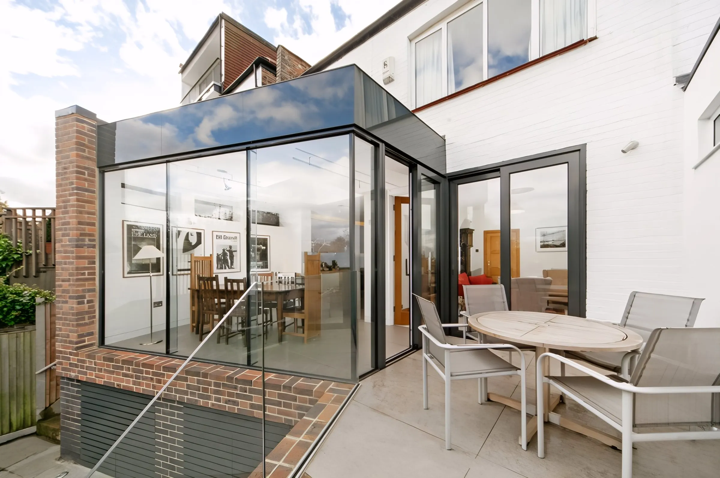 Frameless glazed corner of the extension above the garden terrace