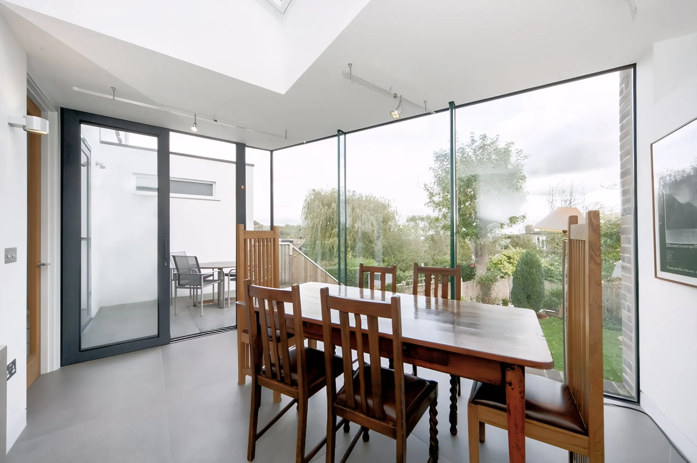Dining area inside the extension with full-height glass and rooflight