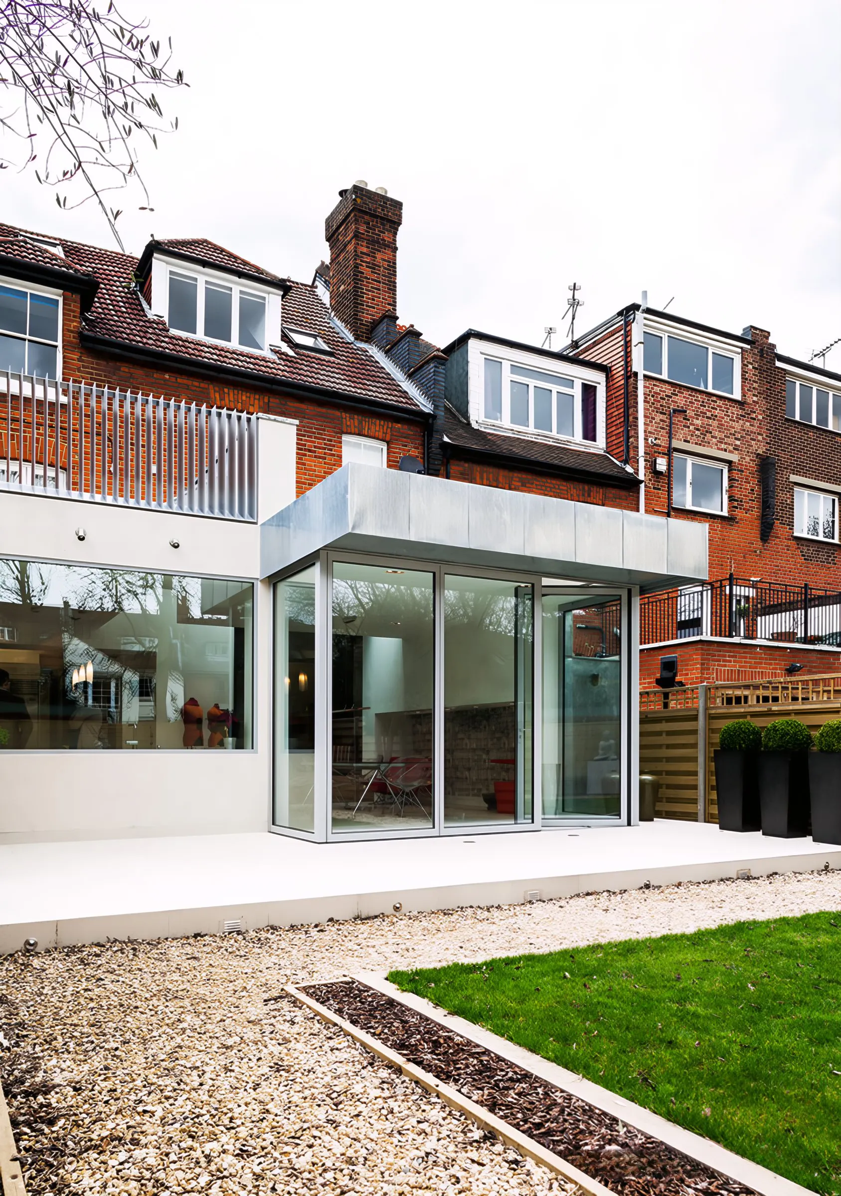 Crouch Hall rear extension with frameless glazing, seen across the garden