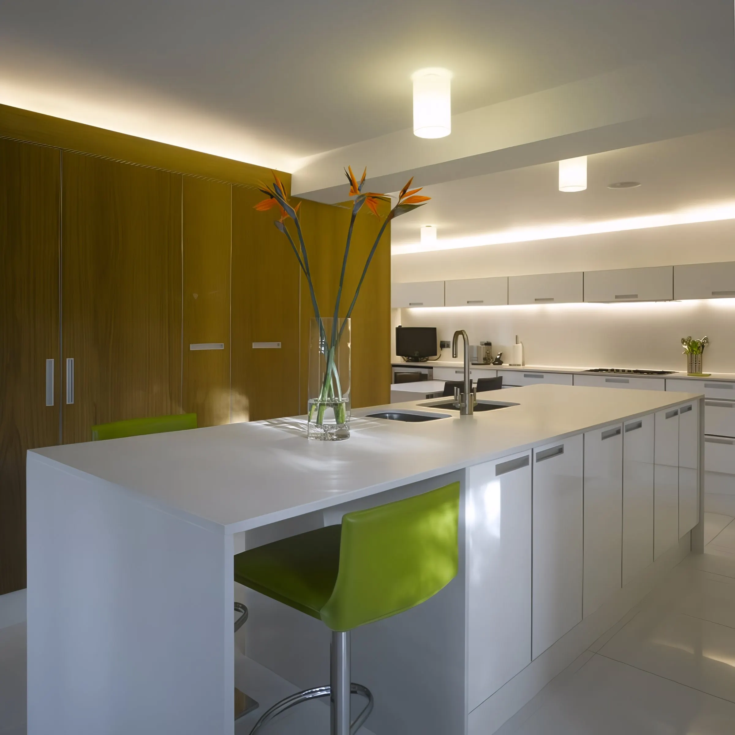 Kitchen with lime green bar stools under concealed lighting