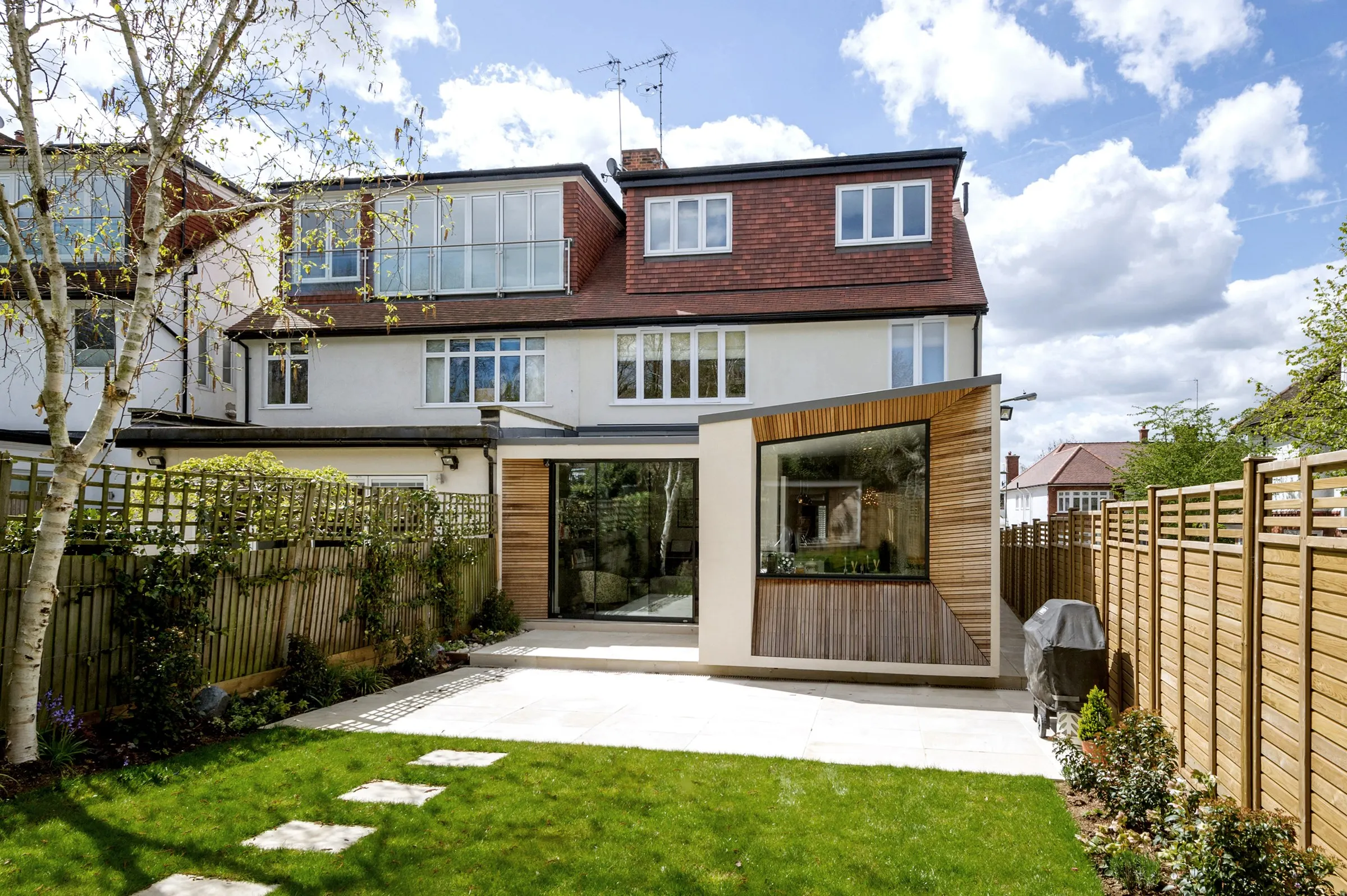 Completed rear extension at Lyndale with cedar-clad window box and sliding doors to the garden