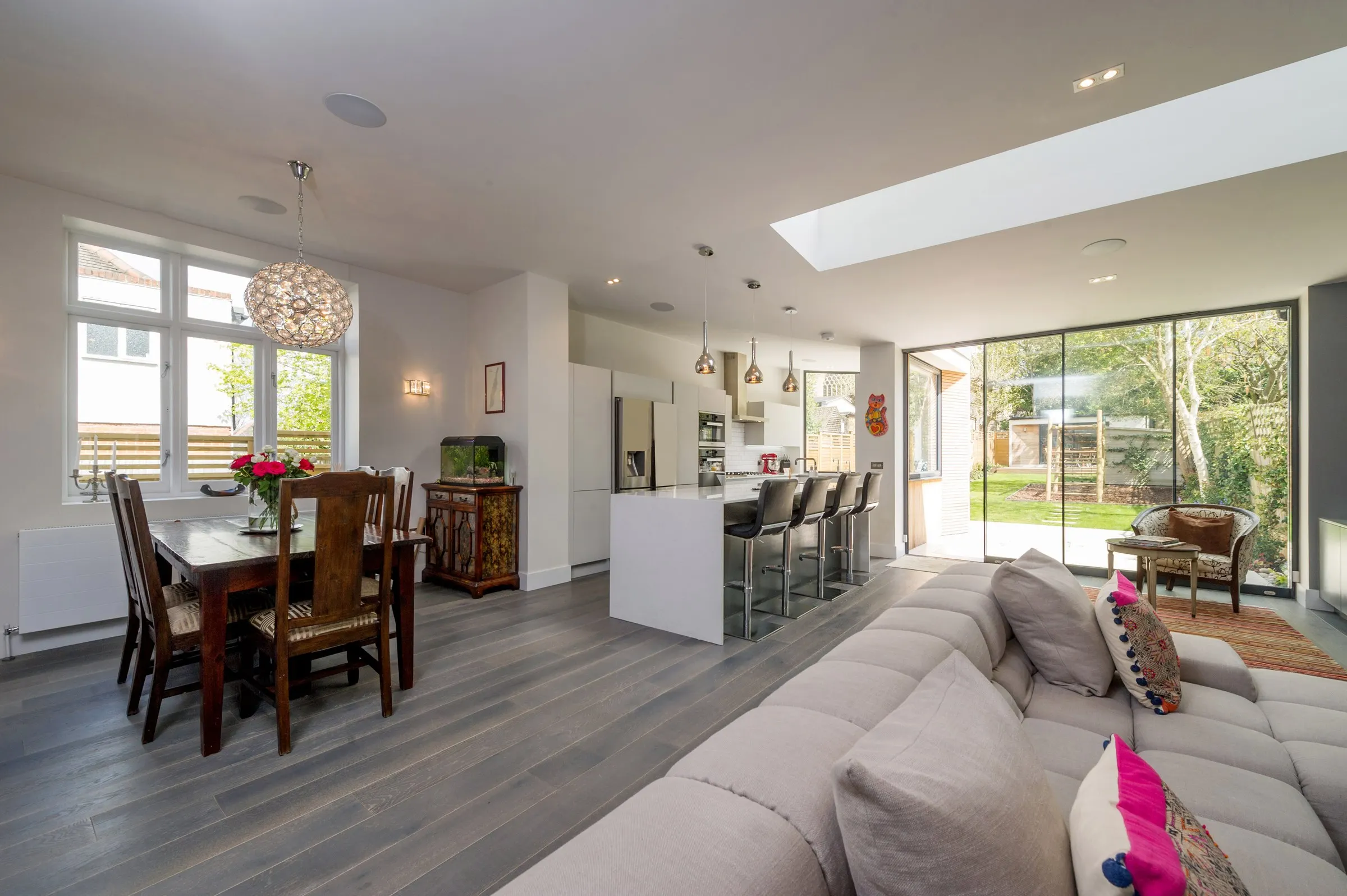 Open-plan kitchen, dining and living space with rooflight and garden views