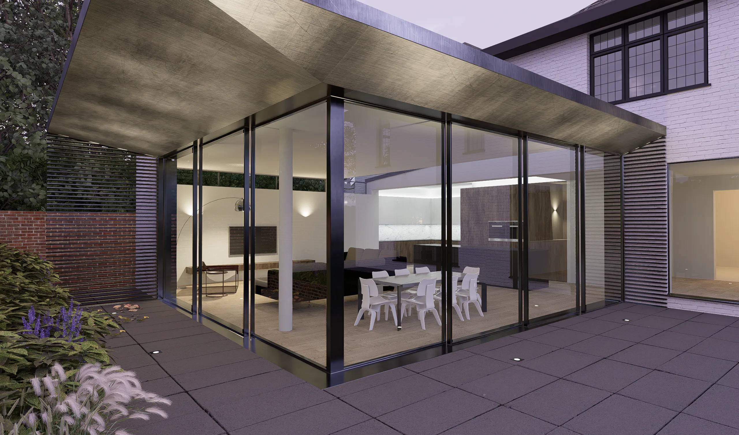 Corner of the glazed extension at dusk, with the dining space lit inside
