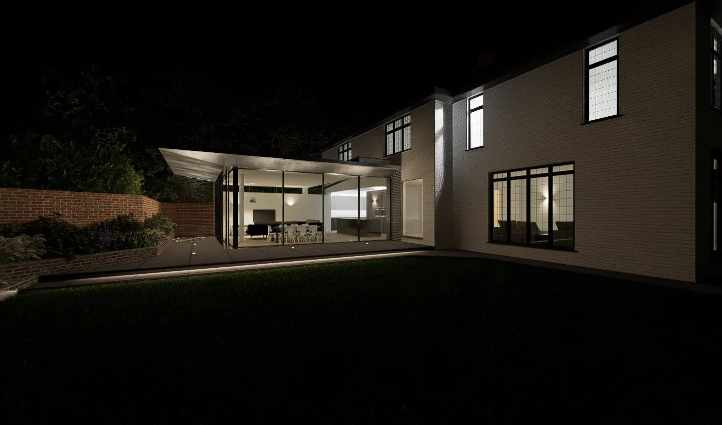 The extension at night, glowing against the dark garden